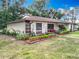 Charming home with a landscaped yard, flower beds, and decorative touches at 12539 Orangewood Ct, Tavares, FL 32778