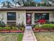 Charming home with a landscaped yard, flower beds, and decorative touches at 12539 Orangewood Ct, Tavares, FL 32778