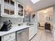 Bright kitchen area with stainless steel dishwasher, double sinks, white cabinets and adjacent dining area at 12539 Orangewood Ct, Tavares, FL 32778