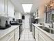 Well-lit kitchen featuring white cabinetry, stainless steel appliances, and a spacious layout at 12539 Orangewood Ct, Tavares, FL 32778