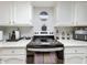 Clean kitchen with white countertops and cabinets, featuring a black range and stainless steel appliances at 12539 Orangewood Ct, Tavares, FL 32778