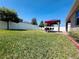 A spacious backyard with a green lawn and a beautiful gazebo set on a brick patio at 1321 Yorkdale Rd, Davenport, FL 33837