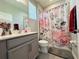 A full bathroom features a shower-tub combination with a floral shower curtain and grey vanity at 1321 Yorkdale Rd, Davenport, FL 33837