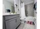 Well-lit bathroom featuring a gray vanity and a shower over a tub at 1321 Yorkdale Rd, Davenport, FL 33837