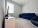 Minimalist bedroom with a blue sofa and a large window at 1321 Yorkdale Rd, Davenport, FL 33837