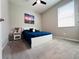 This neutral bedroom includes a bed with a blue comforter, carpeted floor, and natural light at 1321 Yorkdale Rd, Davenport, FL 33837