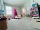 A charming bedroom with neutral walls and carpet, a dollhouse, and a tented crib at 1321 Yorkdale Rd, Davenport, FL 33837