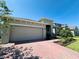 Charming home featuring a two-car garage, a brick driveway, and well-maintained landscaping at 1321 Yorkdale Rd, Davenport, FL 33837
