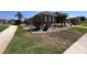 A home with a green lawn and beautiful rock landscaping with several bushes and green trees at 1321 Yorkdale Rd, Davenport, FL 33837