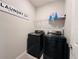 Modern laundry room featuring new front load washer and dryer, with storage shelf at 1321 Yorkdale Rd, Davenport, FL 33837