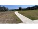 A paved walking path winds through a grassy area leading to a serene lake at 1321 Yorkdale Rd, Davenport, FL 33837
