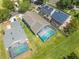 An aerial view of a backyard with a screened-in pool and lush green landscaping at 1338 Lake Biscayne Way, Orlando, FL 32824