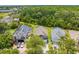 An aerial view of three beautiful houses and a backyard with lush green trees at 1338 Lake Biscayne Way, Orlando, FL 32824