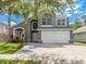 Charming two-story home with well-manicured lawn, palm trees, and a two car garage at 1338 Lake Biscayne Way, Orlando, FL 32824