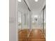 Hallway with wood floors, closet with mirrored doors and view to bathroom with tub and double sinks at 1338 Lake Biscayne Way, Orlando, FL 32824