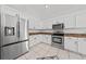 Well-lit kitchen featuring stainless steel appliances, white cabinets, and tile flooring at 1338 Lake Biscayne Way, Orlando, FL 32824
