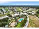 Bird's-eye view of a lush condo community, showcasing a pool, fountain, and nearby golf course at 1501 Northern Harrier Way # 101, Kissimmee, FL 34747