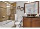 Bathroom featuring a glass-enclosed shower, vanity with dark countertop, and ceramic tiled walls at 1501 Northern Harrier Way # 101, Kissimmee, FL 34747