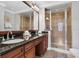 Bright bathroom featuring a double vanity with granite countertops and a glass-enclosed shower at 1501 Northern Harrier Way # 101, Kissimmee, FL 34747