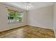 Well-lit bedroom with ceiling fan, neutral walls, and a large window overlooking the exterior of the home at 154 Academy Oaks Pl, Altamonte Springs, FL 32714