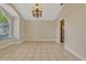 Empty dining room with tile flooring, chandelier, and natural light from a large window at 154 Academy Oaks Pl, Altamonte Springs, FL 32714