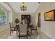 Elegantly staged dining room with table, chairs, buffet, rug and stylish chandelier at 154 Academy Oaks Pl, Altamonte Springs, FL 32714