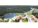 Overhead view highlighting community with pond, tennis courts, and a community pool near lush green landscaping at 1558 Cumin Dr, Poinciana, FL 34759