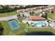 Gorgeous aerial view showcasing the community pool, clubhouse, and tennis courts, surrounded by lush landscaping at 1558 Cumin Dr, Poinciana, FL 34759