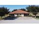 Well-maintained property exterior with a red tile roof, manicured lawn, and tree lined street at 1558 Cumin Dr, Poinciana, FL 34759