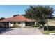 Charming home exterior featuring light-colored walls, red tile roof, screened-in porch and a lush green lawn at 1558 Cumin Dr, Poinciana, FL 34759