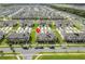 An aerial view of townhomes in a neatly planned community with landscaped grounds and street parking at 1818 Katz Crossing Dr, Kissimmee, FL 34744