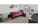 Carpeted bedroom featuring a twin bed, a window with blinds, and playful decorations at 1818 Katz Crossing Dr, Kissimmee, FL 34744