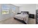 This carpeted bedroom has two windows for natural light, a queen bed, and dual nightstands at 1818 Katz Crossing Dr, Kissimmee, FL 34744