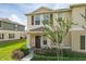 Inviting two-story home with a charming front porch, enhanced by lush landscaping at 1818 Katz Crossing Dr, Kissimmee, FL 34744