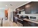 Modern kitchen featuring stainless steel appliances and dark cabinets, ideal for cooking at 1818 Katz Crossing Dr, Kissimmee, FL 34744