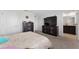 Spacious carpeted bedroom with a large TV, dressers, and ensuite bathroom access at 1818 Katz Crossing Dr, Kissimmee, FL 34744