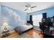 Stylish bedroom with wood floors, a cloud-themed accent wall, and a ceiling fan at 1823 Ashton E Dr, St Cloud, FL 34771