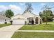 Charming one-story home featuring a manicured lawn and attached two-car garage at 1823 Ashton E Dr, St Cloud, FL 34771