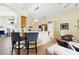 Open-concept kitchen with bar seating, stainless steel refrigerator, and modern lighting at 1823 Ashton E Dr, St Cloud, FL 34771