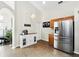 Bright eat in kitchen featuring stainless steel refrigerator, bar area, and tiled flooring at 1823 Ashton E Dr, St Cloud, FL 34771