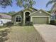 Charming home with an arched entryway, a two-car garage, and lush landscaping at 2365 Paulette Dr, Haines City, FL 33844