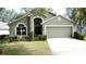 Well-kept home exterior with vibrant green lawn, trimmed bushes, and a welcoming front entrance at 2365 Paulette Dr, Haines City, FL 33844