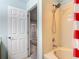Clean bathroom featuring a shower tub with a red and white shower curtain at 247 Verona Ave, Davenport, FL 33897