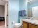 Bright bathroom with light-blue walls, wood cabinets, and a shower at 247 Verona Ave, Davenport, FL 33897