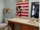 Cheerful bathroom offering ample counter space, a sink, a vanity, and a themed shower curtain at 247 Verona Ave, Davenport, FL 33897