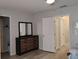 Well-lit bedroom featuring wood floors, closet space, neutral paint, and a mirror-topped dresser at 247 Verona Ave, Davenport, FL 33897