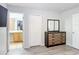 This bedroom features a mirrored dresser, gray walls, hardwood style floors, and access to the bathroom at 247 Verona Ave, Davenport, FL 33897