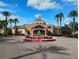 Beautiful exterior view of Regal Palms Resort clubhouse with fountain and palm trees on a sunny day at 247 Verona Ave, Davenport, FL 33897