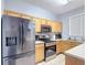 Kitchen with stainless steel appliances, light wood cabinets, and countertops at 247 Verona Ave, Davenport, FL 33897