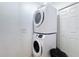 This laundry room features a stacked washer and dryer, along with a door to a storage area at 247 Verona Ave, Davenport, FL 33897